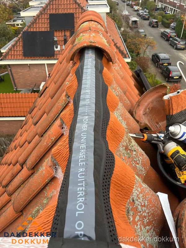 Dakdekker vervangt nokvorst met ruiterrol op pannendak in Dokkum