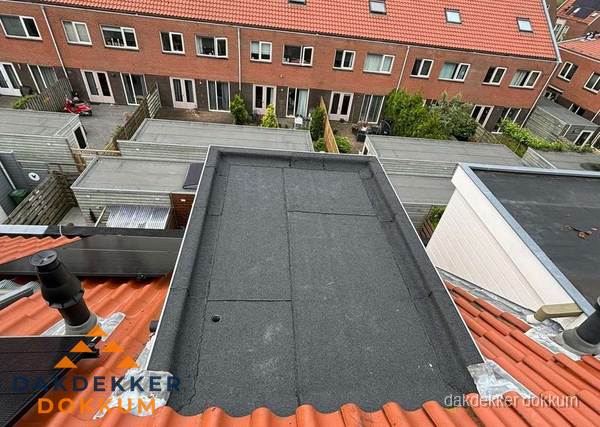 Plat dak met bitumen bedekking naast dakkapel in Dokkum