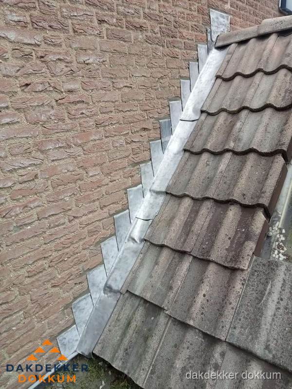 Loodslabben langs dakaansluiting bij bakstenen muur in Dokkum