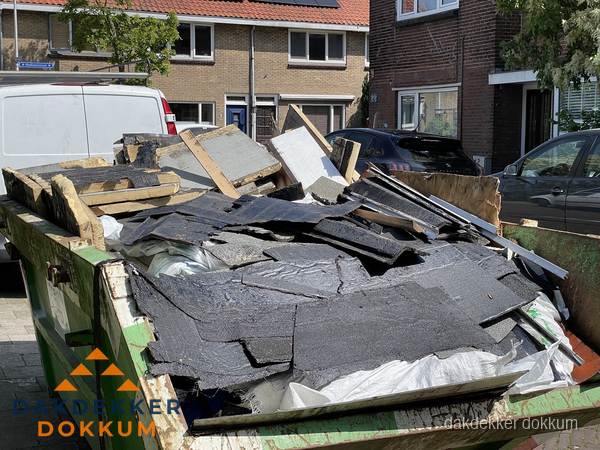 Afvalcontainer met gesloopt dakmateriaal tijdens dakkapel renovatie in Dokkum