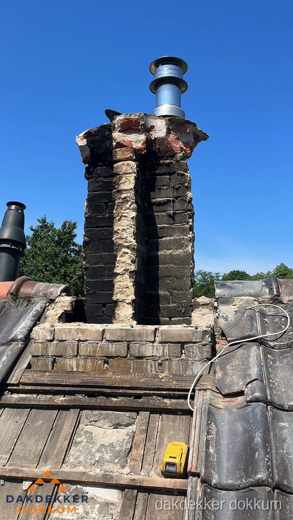 Beschadigde schoorsteen met nieuwe rookgasafvoer op oud dak in Dokkum