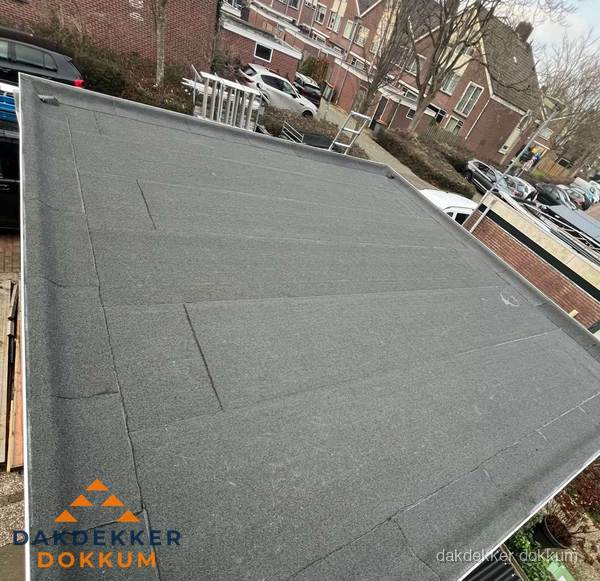 Nieuwe bitumen dakbedekking op plat dak van garage in Dokkum