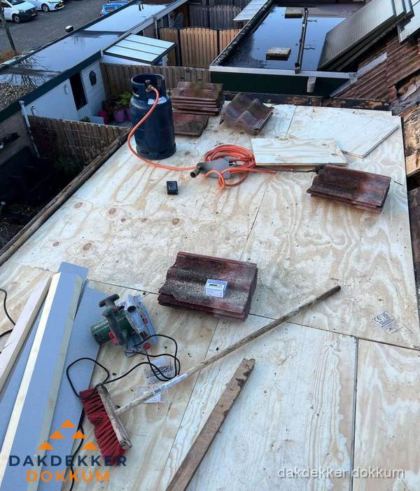 Dakreparatie werkzaamheden op plat dak met gereedschap in Dokkum