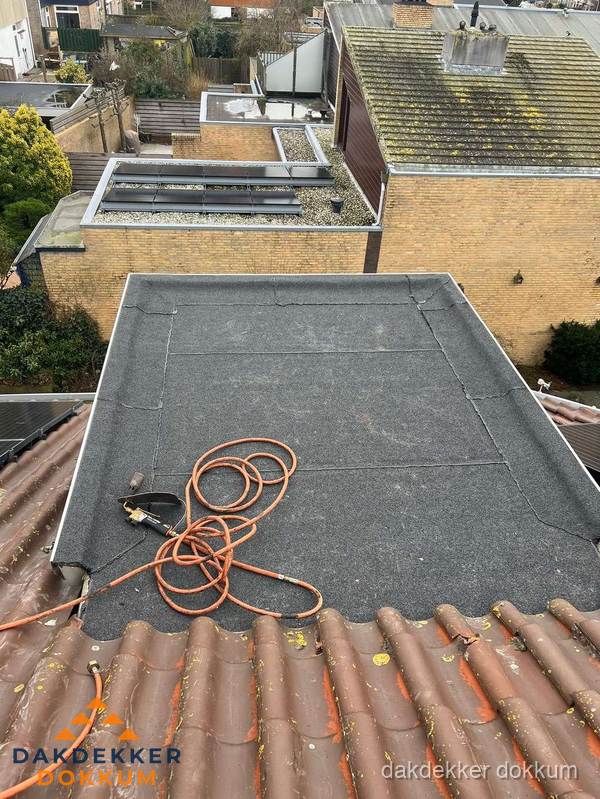 Reparatie aansluiting plat dak en schuin dak in Dokkum