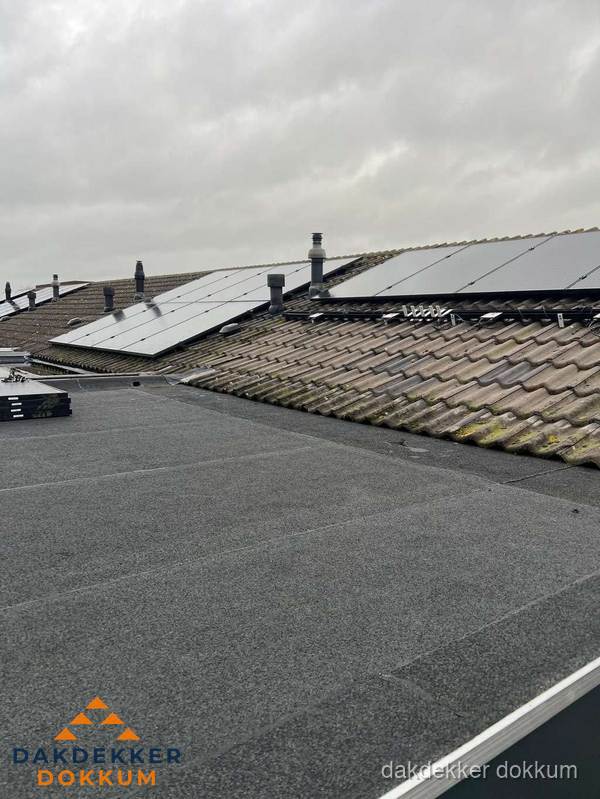 Bitumen dakbedekking op plat dak met aansluitend pannendak en zonnepanelen in Dokkum