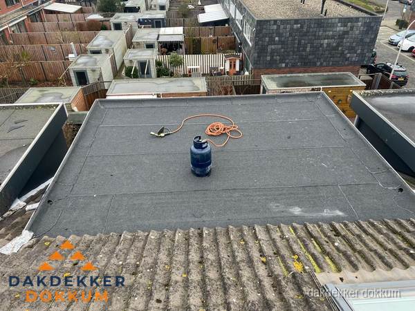 Plat dak met bitumen dakbedekking en brander in Dokkum