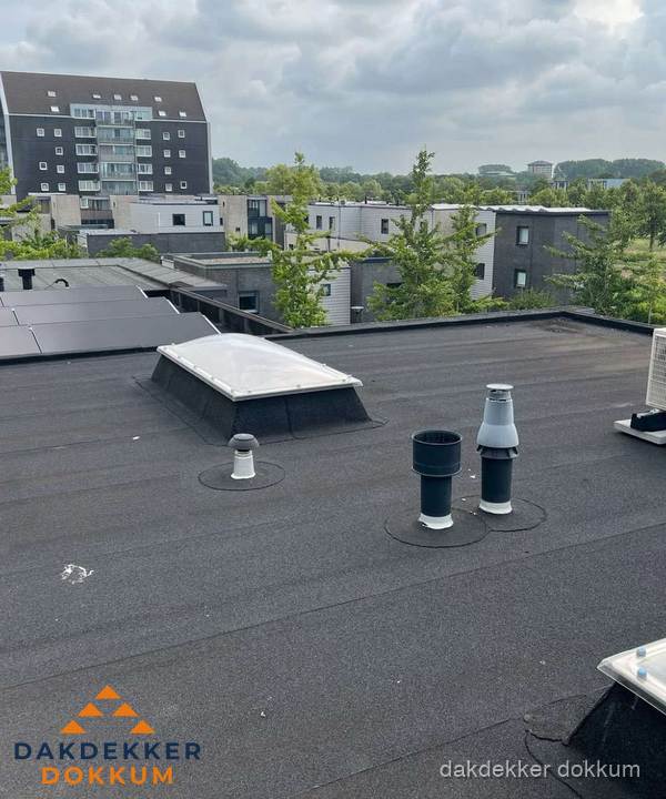 Groot plat dak met lichtkoepel en dakdoorvoeren in Dokkum