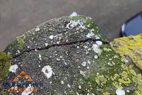 Beschadigde en verweerde nokvorst met scheuren en mos in Dokkum Beschadigde en verweerde nokvorst met scheuren en mos in Dokkum