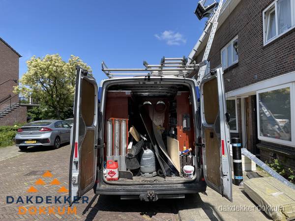 Spoed dakdekker bus met gereedschap en ladder bij woning in Dokkum