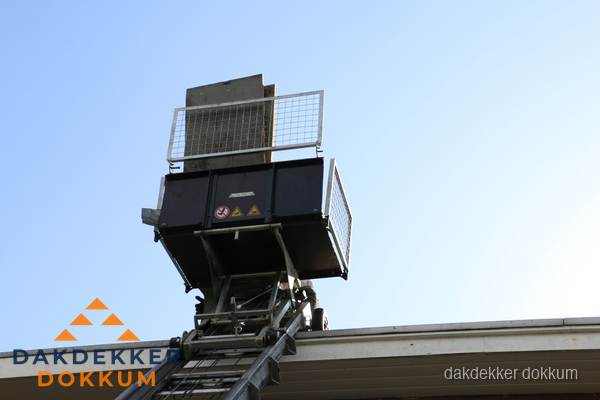 Dakdekkerslift voor materiaal transport bij dakwerkzaamheden in Dokkum