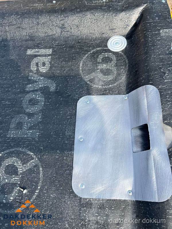 Dakdoorvoer met metalen afvoerplaat op bitumen dak in Dokkum