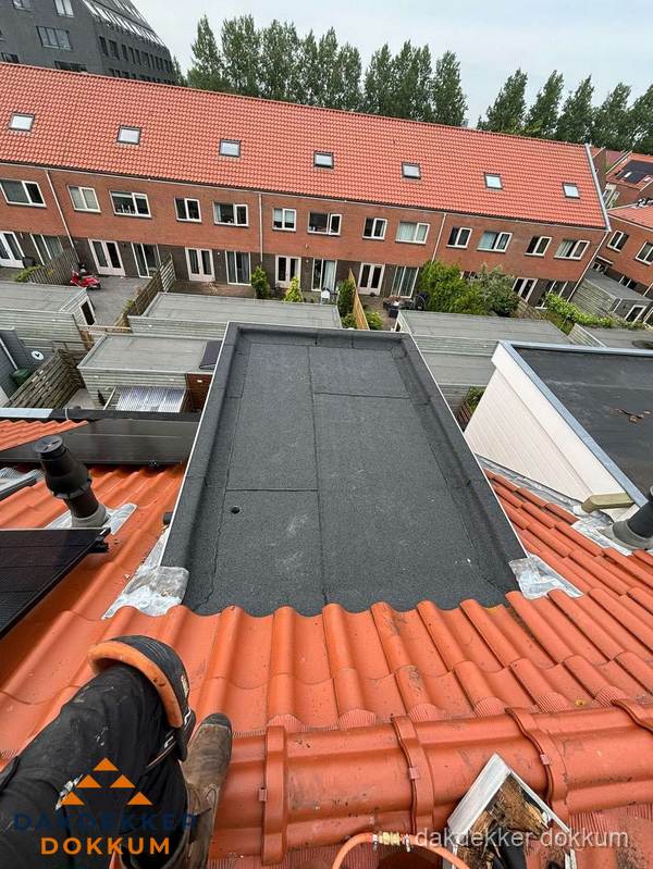 Bitumen dak reparatie op plat dak tussen dakpannen in Dokkum