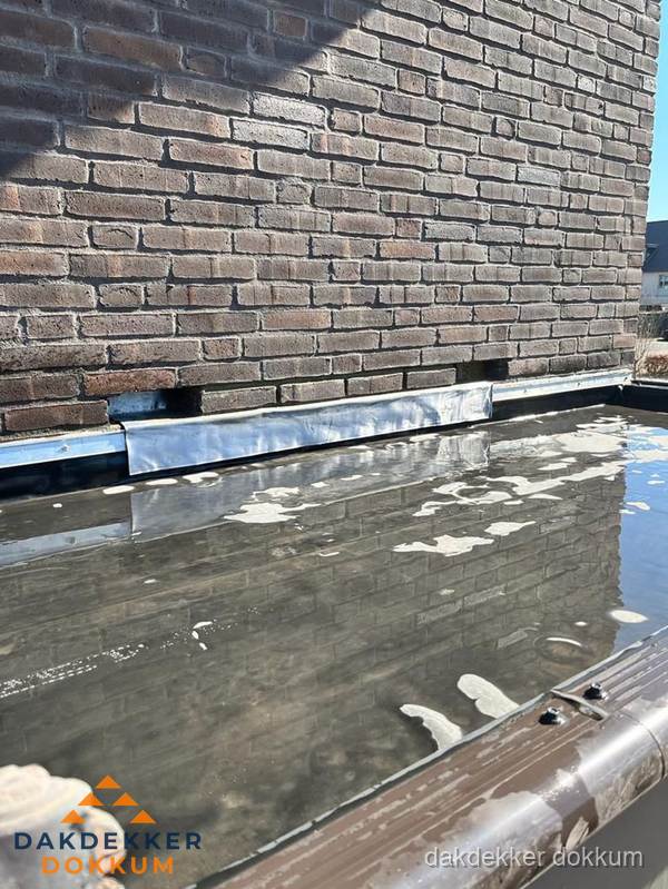 Stilstaand water op plat dak door slechte afwatering in Dokkum