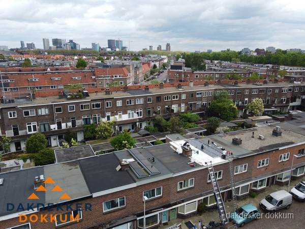 Spoed dakdekker aan het werk op plat dak in woonwijk Dokkum